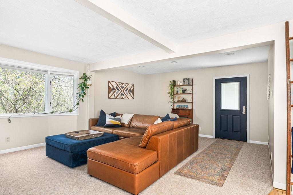5465 Arnold Road Duluth, MN 55803 - Photo 15 of 49 Carpeted living room with baseboards, beam ceiling, and a textured ceiling