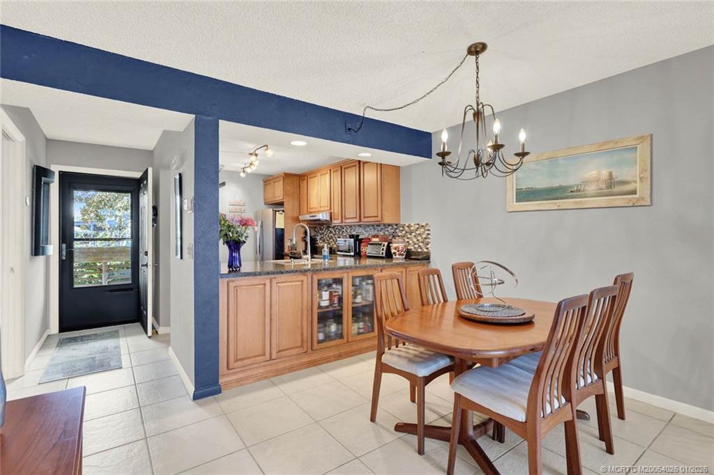 1950 Southwest Palm City Road, Unit 8106 Stuart, FL 34994 - Photo 13 of 54 a view of a dining room with furniture and chandelier