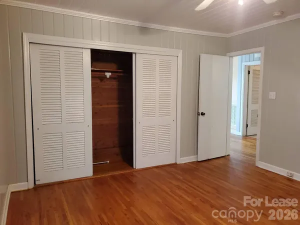 a view of empty room with wooden floor