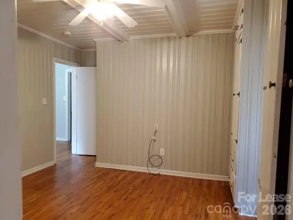a view of an empty room with wooden floor
