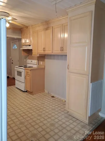 a kitchen with granite countertop a refrigerator and a stove top oven