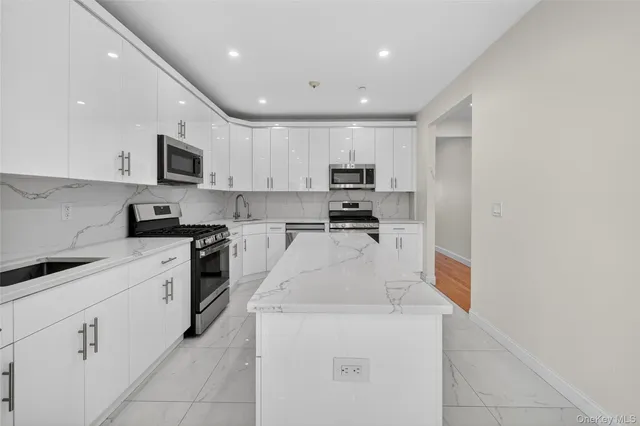 a kitchen with granite countertop a stove a sink and a microwave