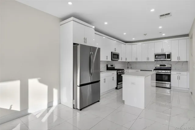 a kitchen with a refrigerator and a stove top oven
