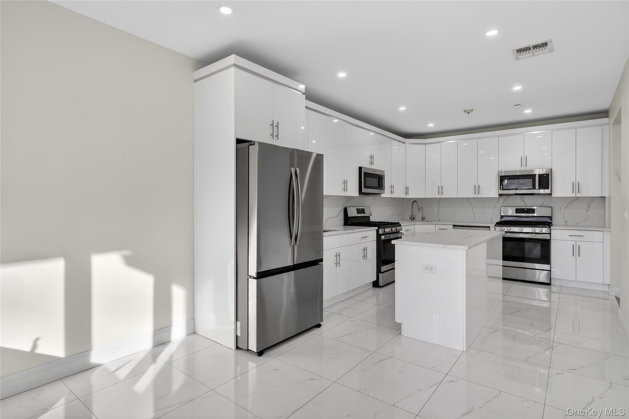 2 Bluefield Drive, Unit 103 Spring Valley, NY 10977 - Photo 17 of 42 a kitchen with kitchen island a counter top space a refrigerator and cabinets