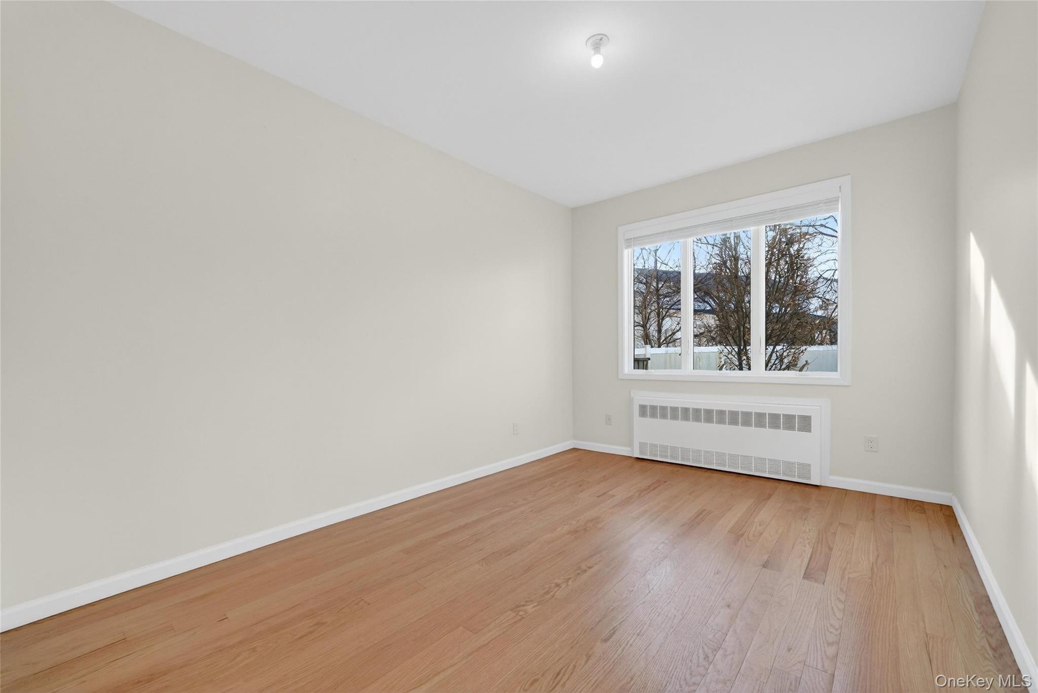 2 Bluefield Drive, Unit 103 Spring Valley, NY 10977 - Photo 23 of 42 an empty room with wooden floor and windows