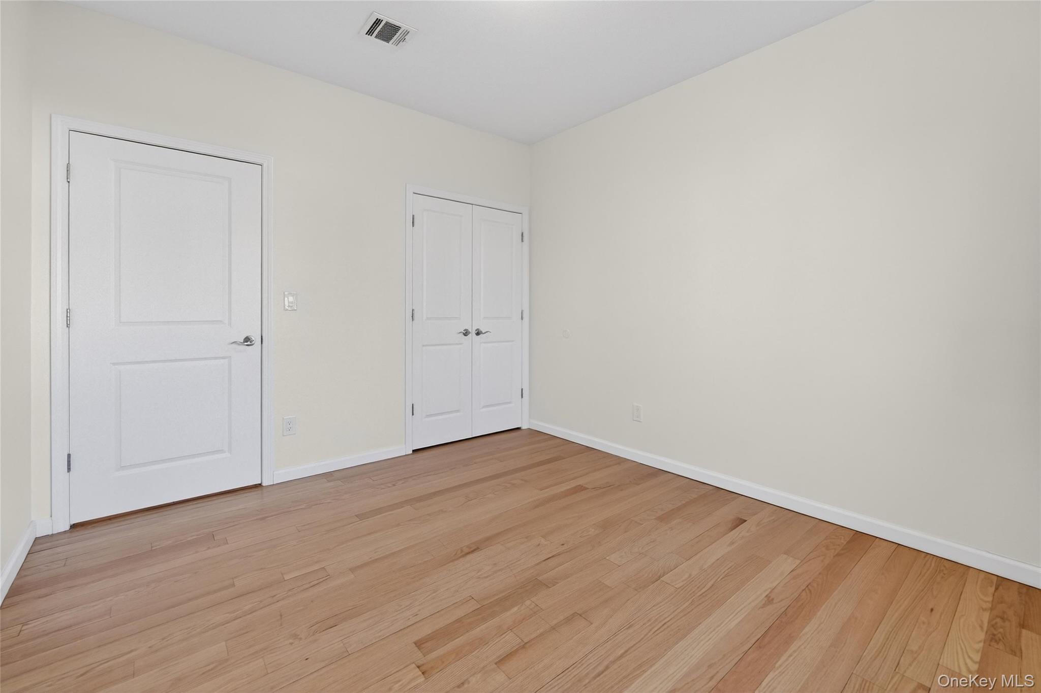 2 Bluefield Drive, Unit 103 Spring Valley, NY 10977 - Photo 32 of 42 a view of an empty room with wooden floor