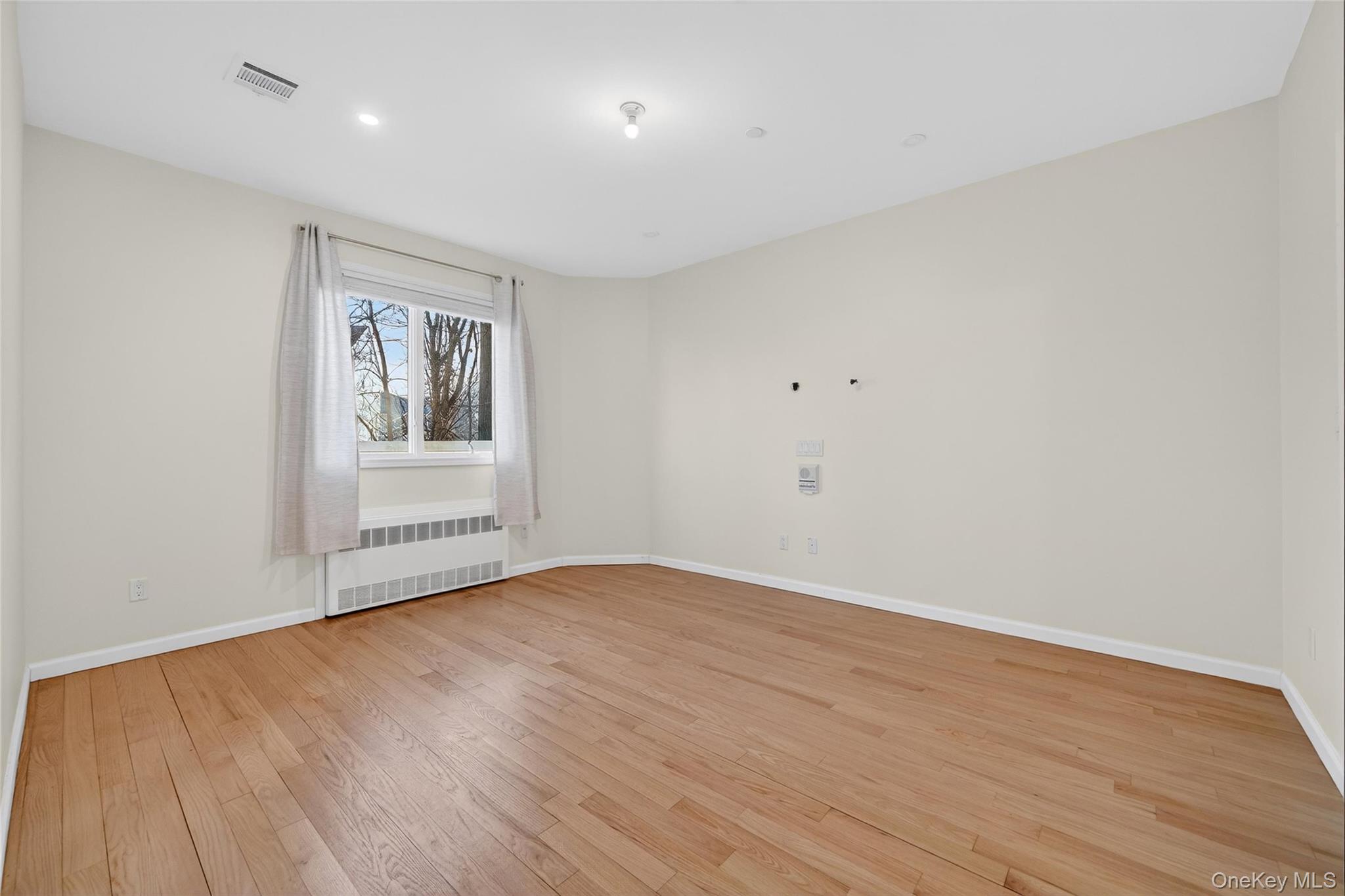 2 Bluefield Drive, Unit 103 Spring Valley, NY 10977 - Photo 34 of 42 a view of an empty room with wooden floor and a window