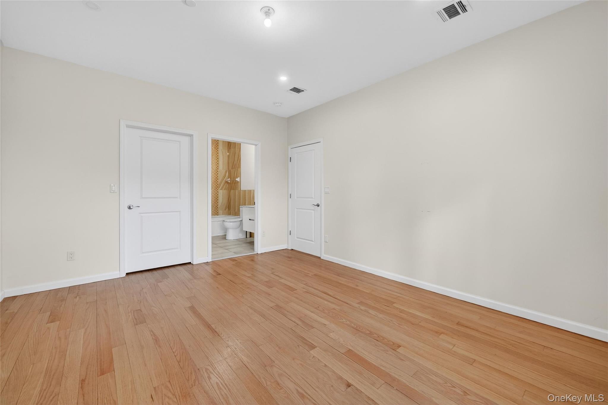 2 Bluefield Drive, Unit 103 Spring Valley, NY 10977 - Photo 35 of 42 Unfurnished bedroom featuring light wood finished floors, connected bathroom, and recessed lighting