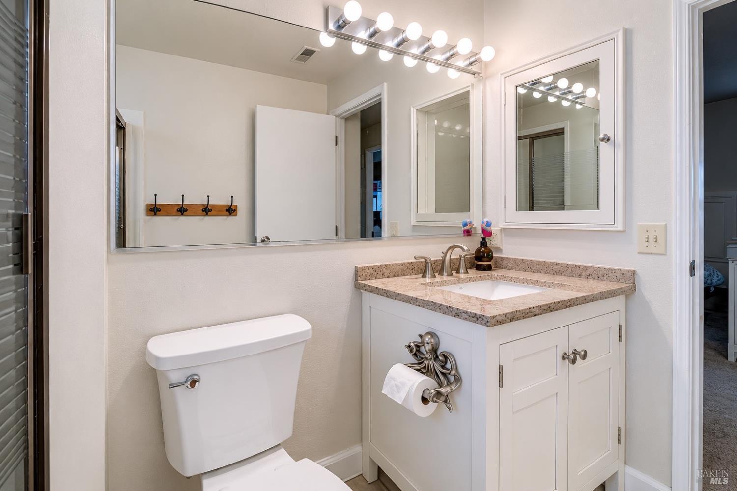 989 Suffolk Way Fairfield, CA 94533 - Photo 20 of 30 a bathroom with a granite countertop sink a toilet and a mirror