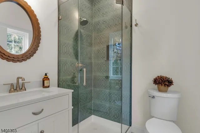 a bathroom with a toilet sink vanity and mirror