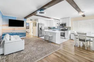 a living room with stainless steel appliances furniture and a kitchen view