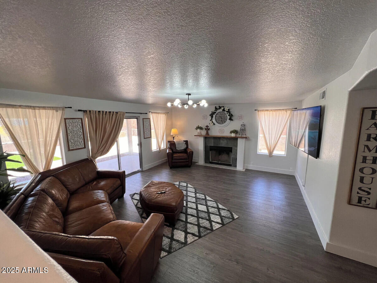 8322 West McLellan Road Glendale, AZ 85305 - Photo 13 of 30 a living room with furniture a fireplace and wooden floor