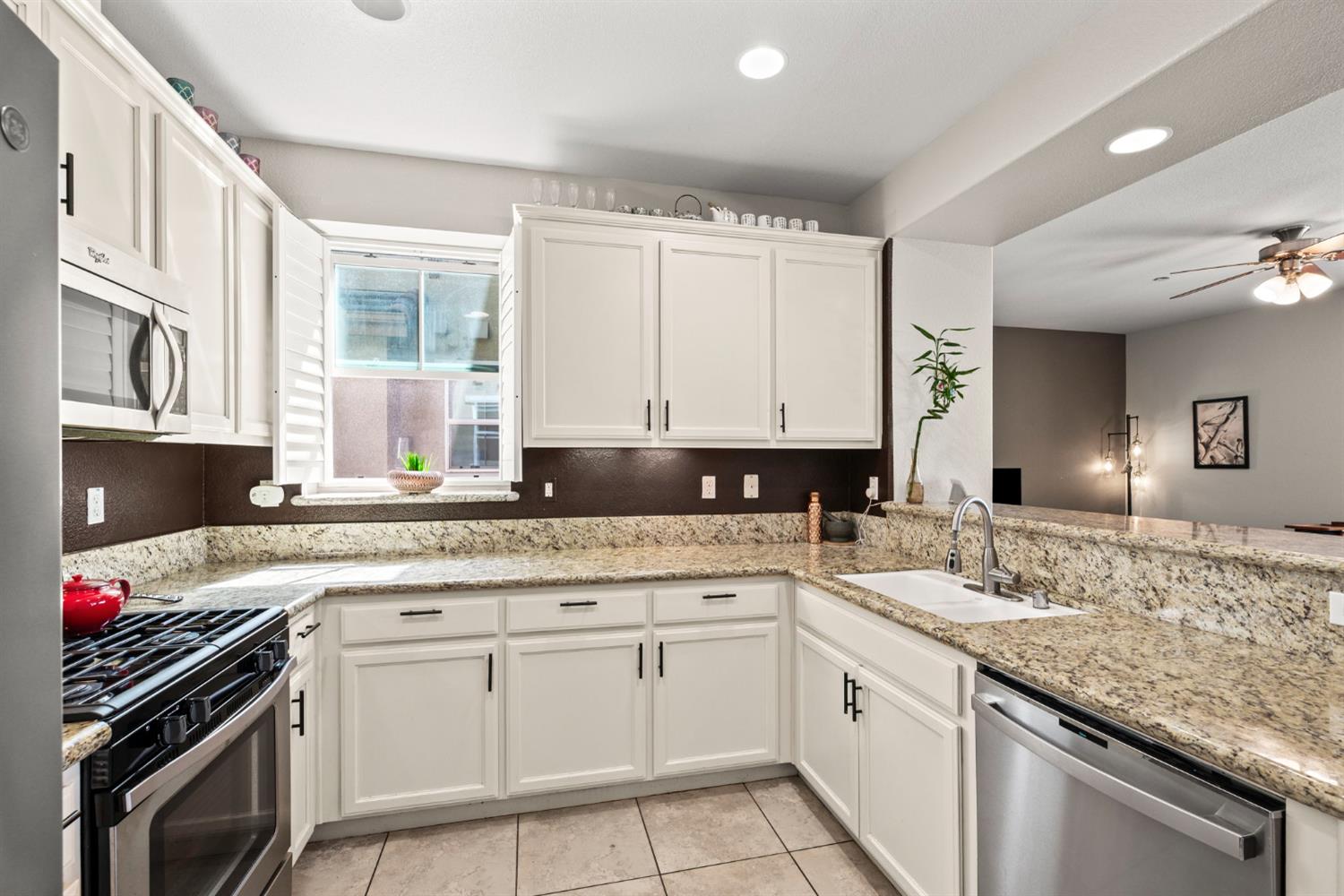 203 Rivage Circle, Unit 203 Folsom, CA 95630 - Photo 11 of 30 a kitchen with granite countertop a sink stove and cabinets
