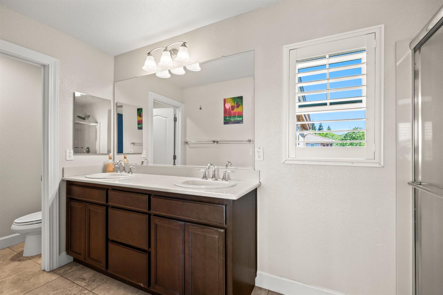 203 Rivage Circle, Unit 203 Folsom, CA 95630 - Photo 20 of 30 a bathroom with a double vanity sink and a mirror