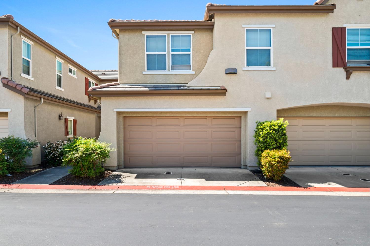 203 Rivage Circle, Unit 203 Folsom, CA 95630 - Photo 2 of 30 a front view of a house with a yard and a garage
