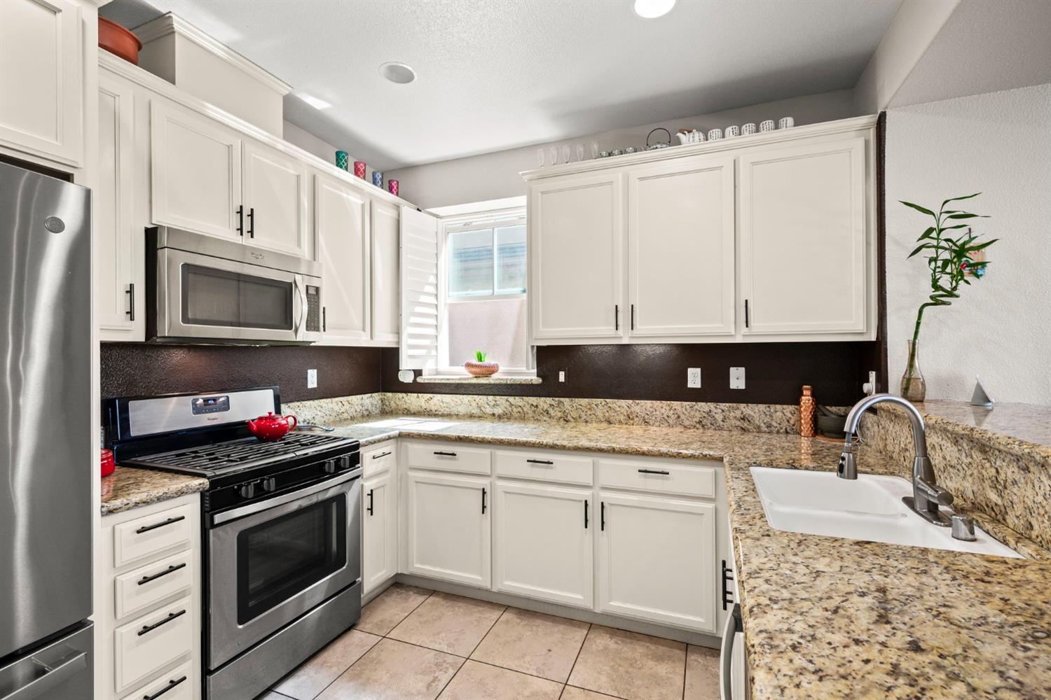 203 Rivage Circle, Unit 203 Folsom, CA 95630 - Photo 10 of 30 a kitchen with white cabinets and appliances
