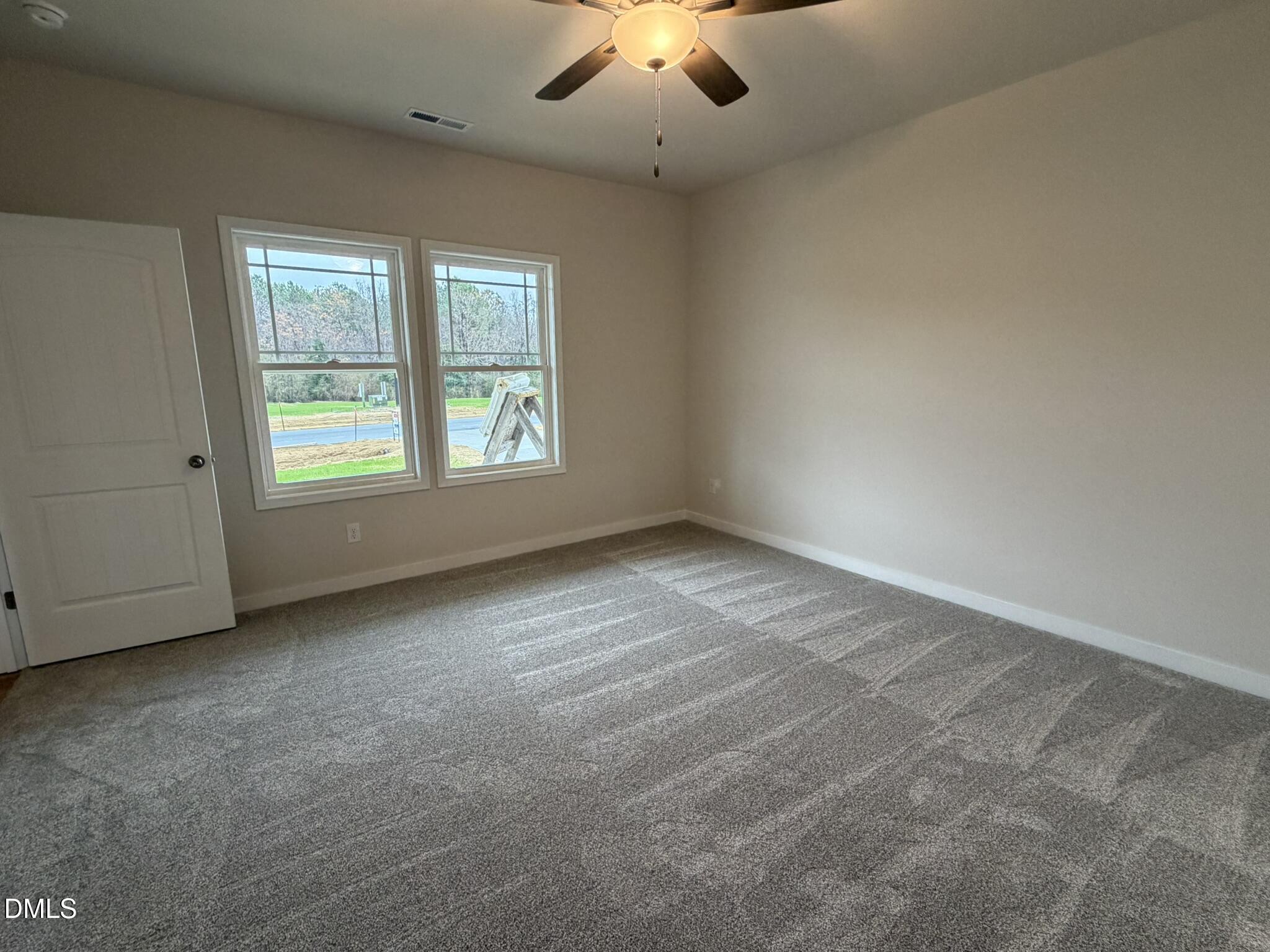 219 Jacobs Ridge Drive Four Oaks, NC 27524 - Photo 10 of 19 an empty room with windows and fan
