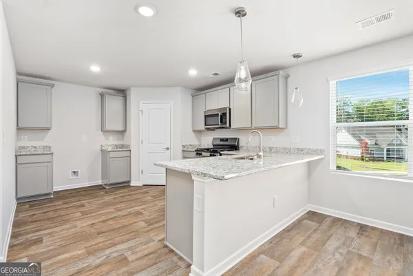 a kitchen with kitchen island a sink stainless steel appliances and window