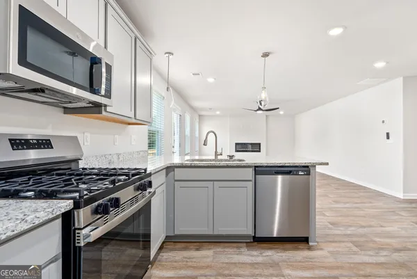 a kitchen with stainless steel appliances granite countertop a sink stove and cabinets