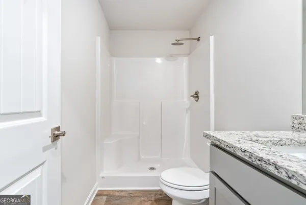 a bathroom with a granite countertop sink toilet and shower