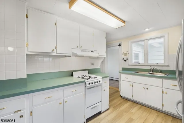 a kitchen with granite countertop a sink a stove and cabinets