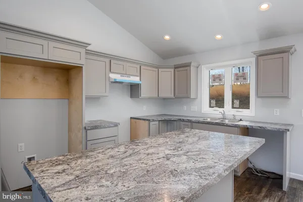 a kitchen with kitchen island a sink stove and refrigerator