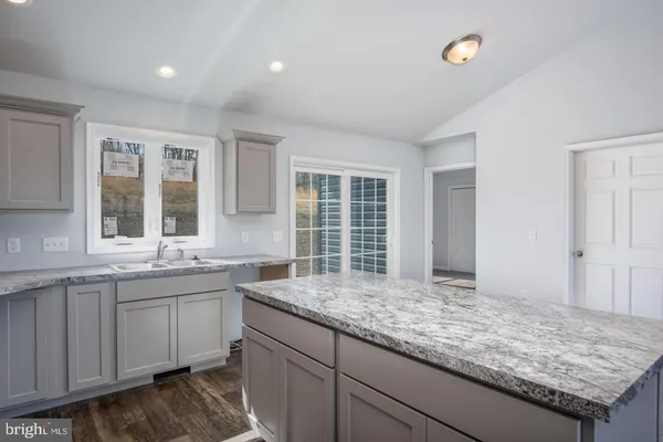 a kitchen with granite countertop sink and cabinets