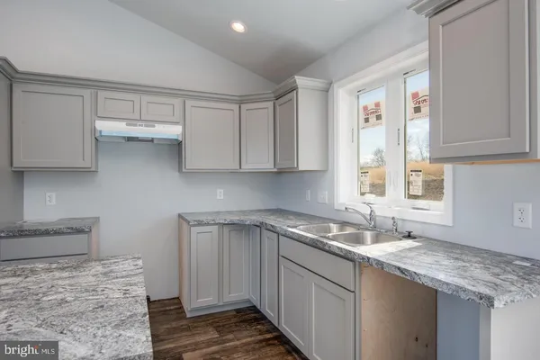 a kitchen with stainless steel appliances granite countertop a sink and a white cabinets