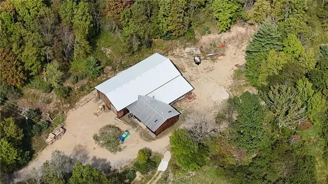 an aerial view of a house with a yard and trees
