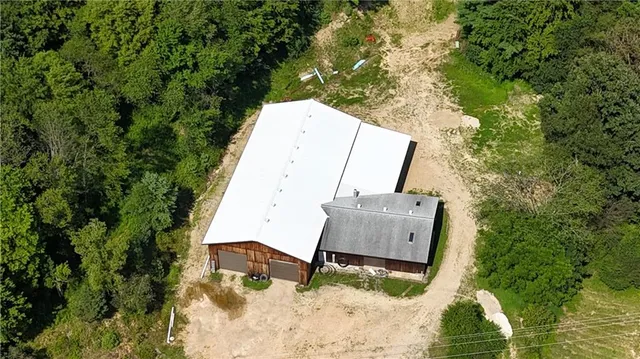 an aerial view of house with yard and trees in the background