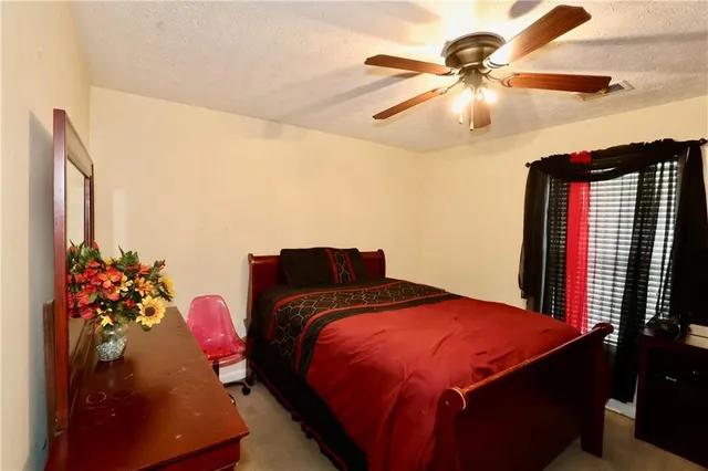 a bedroom with a bed and a flat tv screen on dresser
