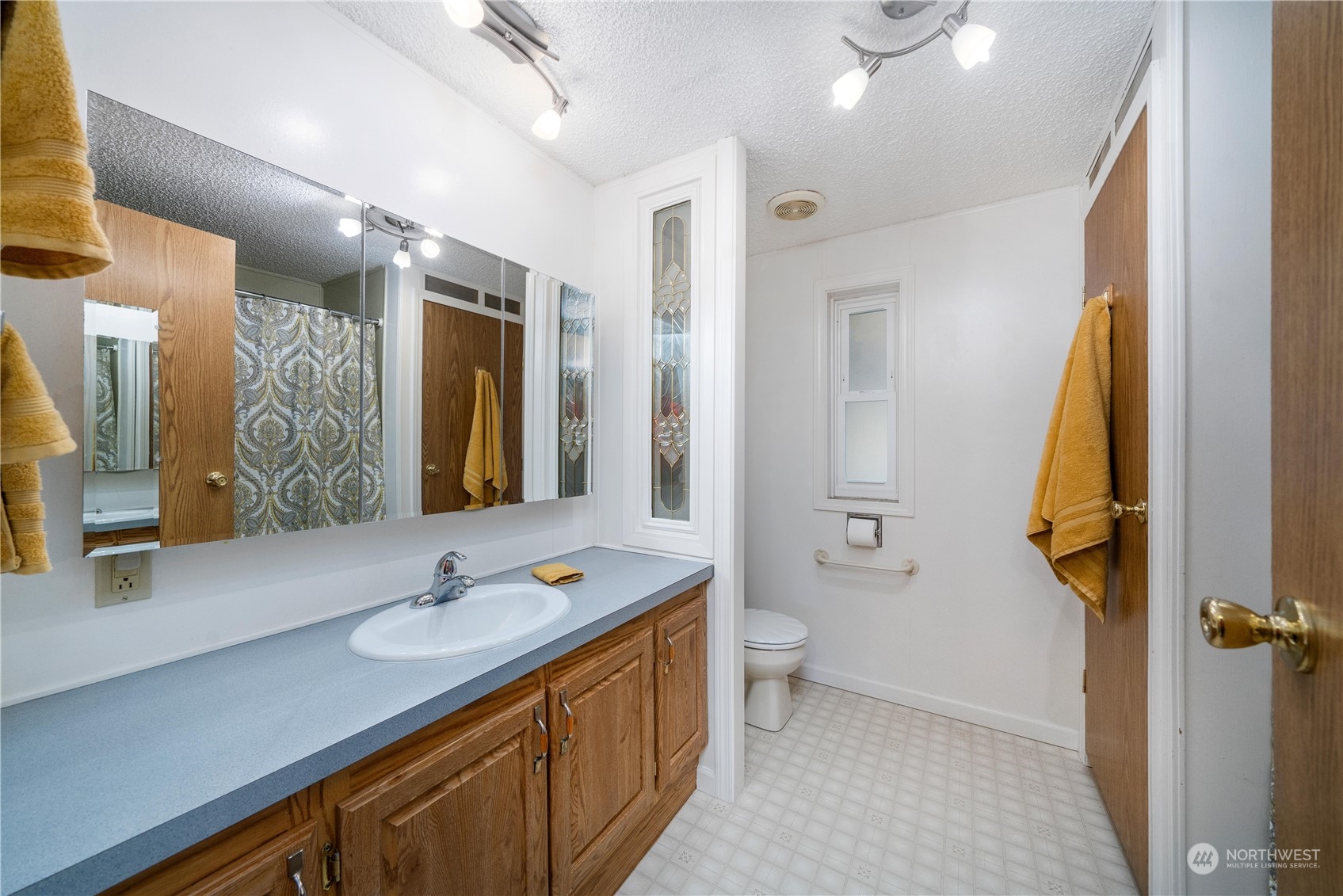9320 Northeast North Shore Road Belfair, WA 98528 - Photo 32 of 40 a bathroom with a sink a toilet and a large mirror