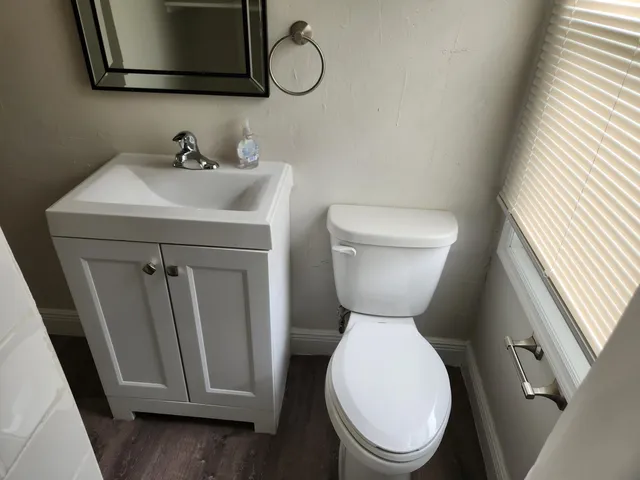 a bathroom with a toilet sink and mirror