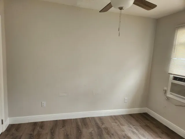 a view of a room with wooden floor and window