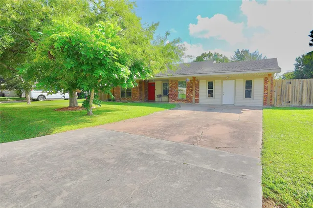 a front view of a house with a yard and trees