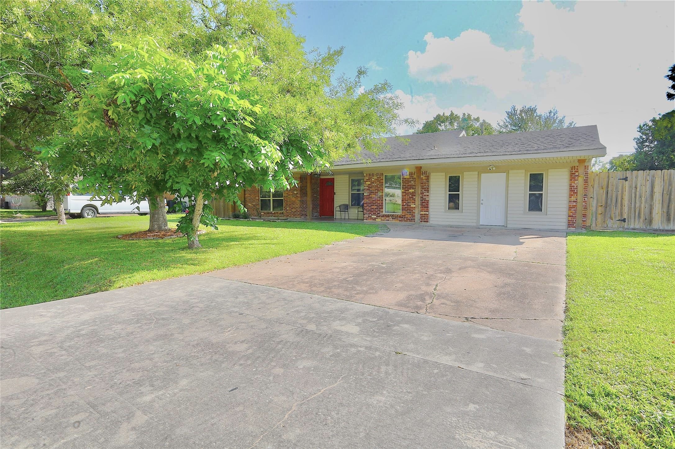 a front view of a house with a yard and trees