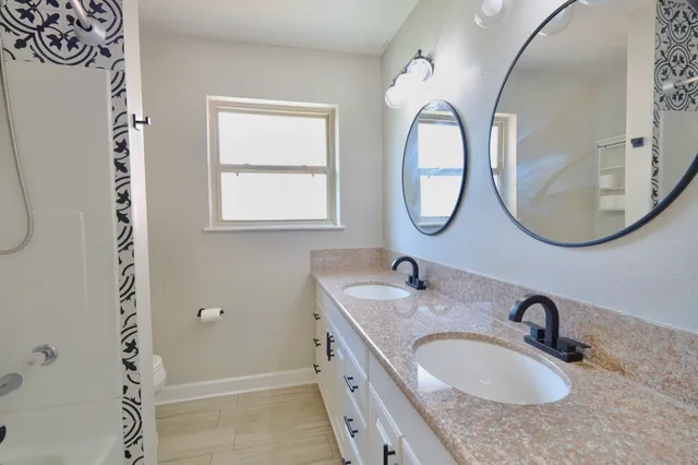 a bathroom with a granite countertop sink and a mirror