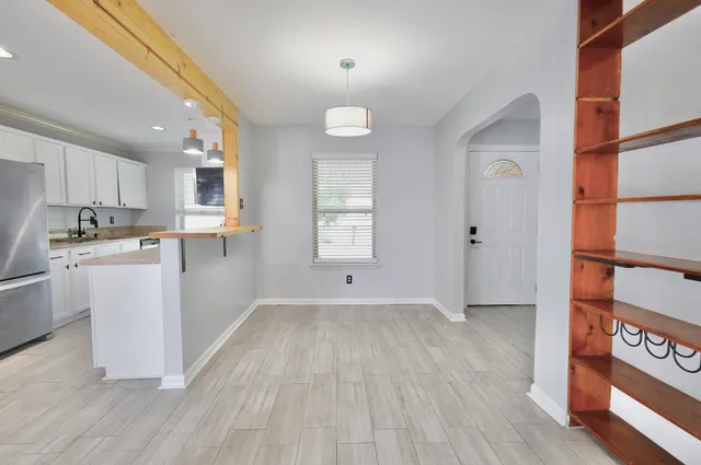 a kitchen with wooden floors and white cabinets