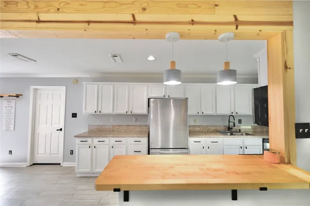 a kitchen with stainless steel appliances granite countertop a sink refrigerator and cabinets
