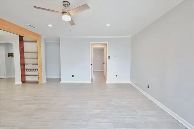 an empty room with closet and a ceiling fan
