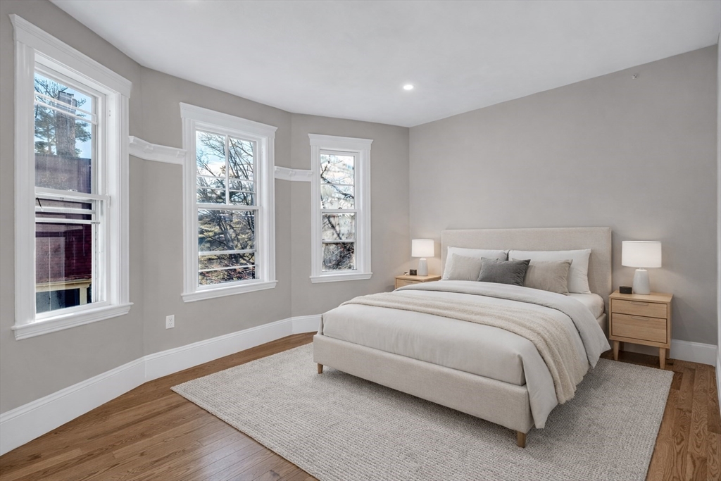 24 Pleasant Street, Unit 2 Boston, MA 02125 - Photo 1 of 8 a bedroom with a bed lamp and a large window