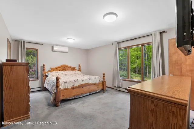 a bedroom with a bed and a large window