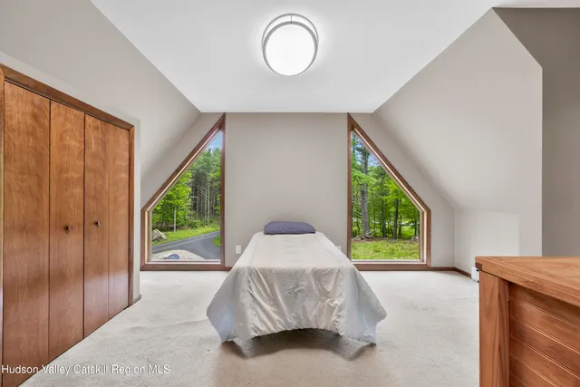 a bedroom with a bed and a large window