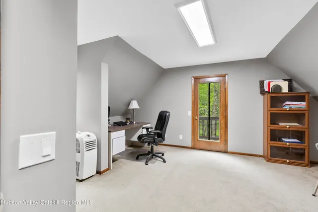 a view of a workspace with furniture and a window