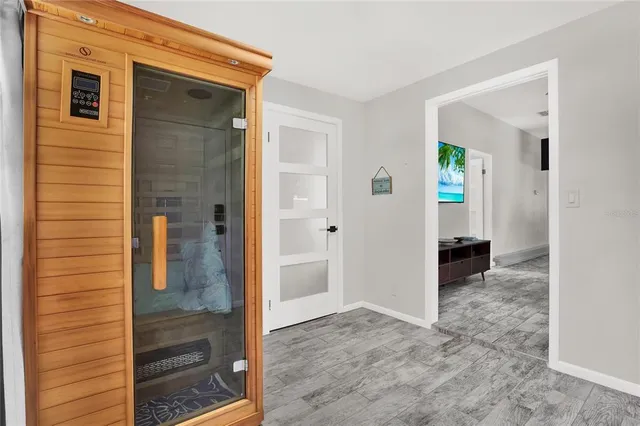 a view of a hallway with wooden cabinets and dining room view