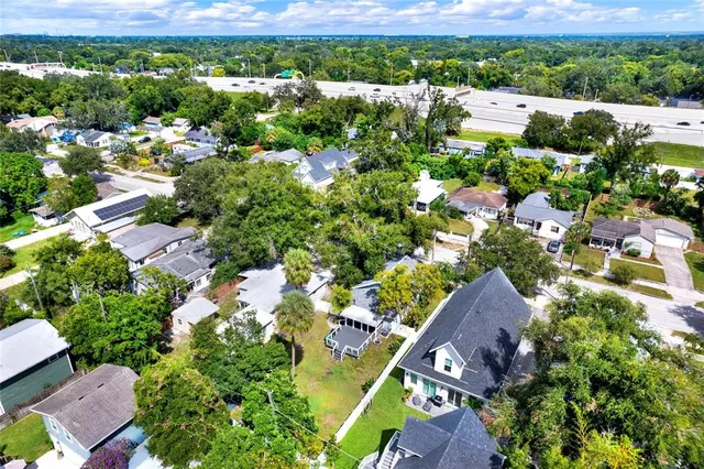 an aerial view of residential houses with outdoor space and trees