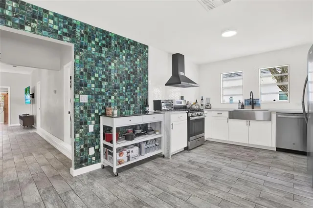a kitchen with stainless steel appliances a stove top oven and a refrigerator