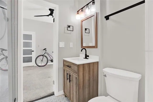a bathroom with a toilet sink vanity and mirror