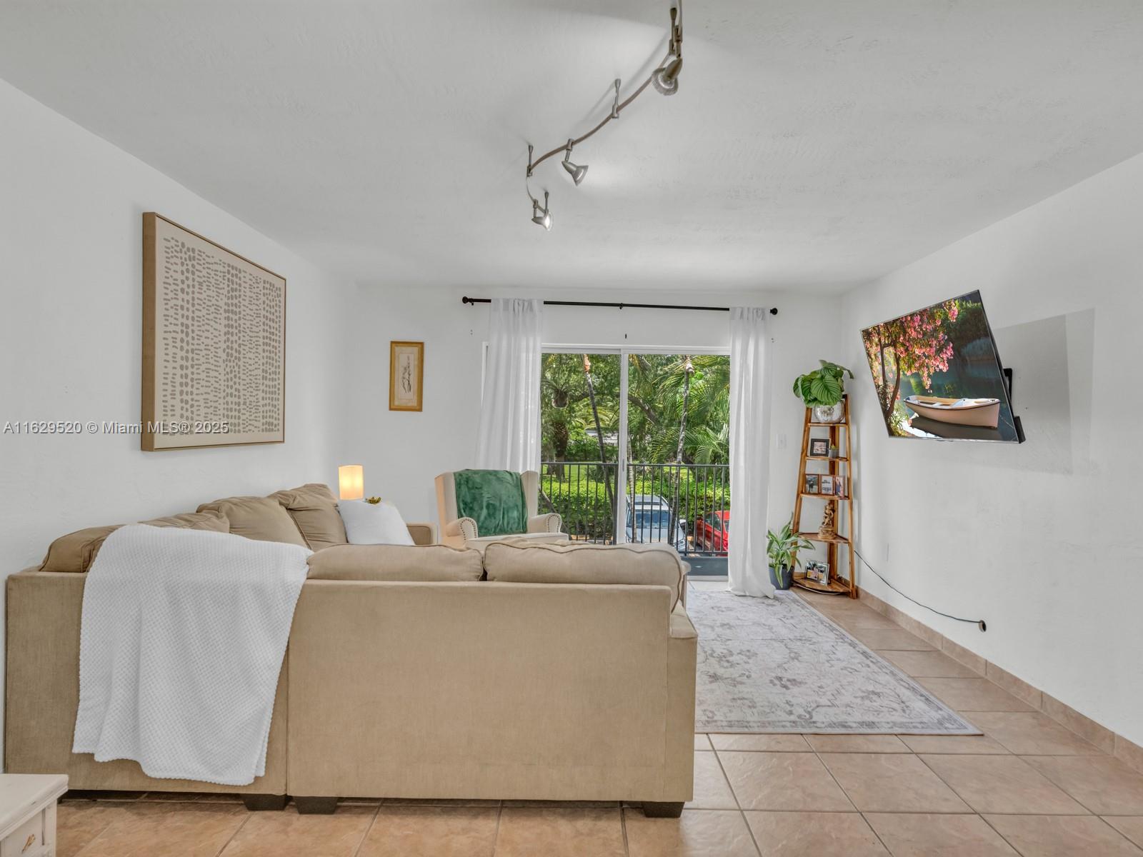 7403 Southwest 82nd Street, Unit 201N Miami, FL 33143 - Photo 17 of 43 a living room with furniture and a flat screen tv