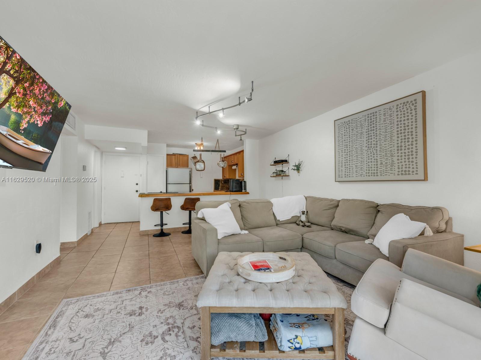 7403 Southwest 82nd Street, Unit 201N Miami, FL 33143 - Photo 21 of 43 a living room with furniture and a flat screen tv